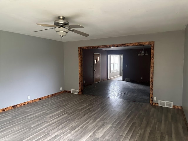 empty room with ceiling fan and dark hardwood / wood-style flooring