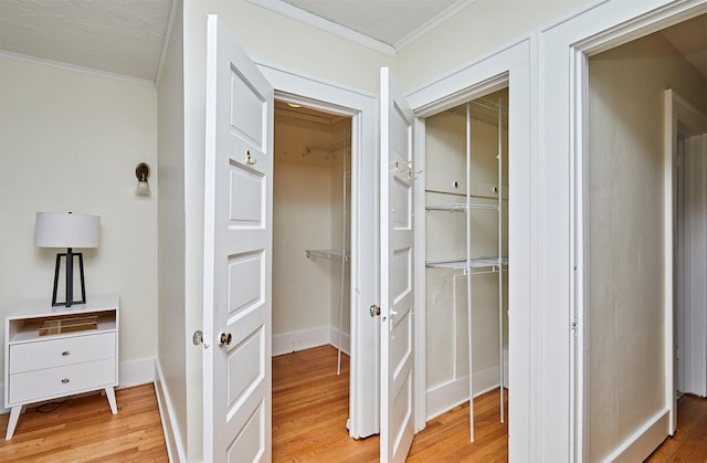 hall featuring crown molding and light hardwood / wood-style flooring