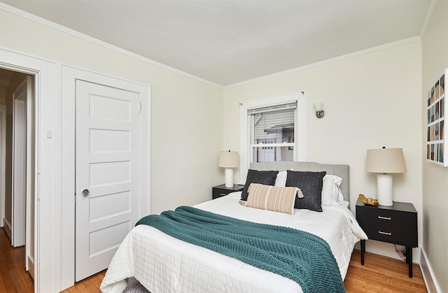 bedroom featuring ornamental molding and light hardwood / wood-style floors