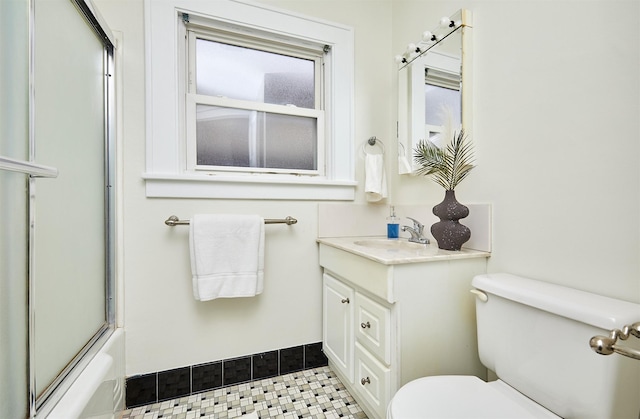 full bathroom with tile patterned floors, vanity, toilet, and combined bath / shower with glass door