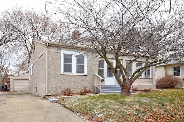 view of front of property featuring an outbuilding, a garage, and a front yard