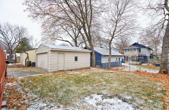 view of yard with a garage, central AC, and an outbuilding