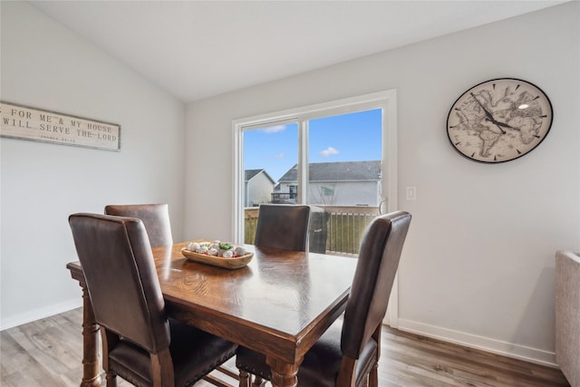 dining space with hardwood / wood-style floors and vaulted ceiling