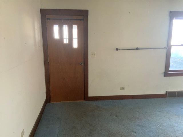 foyer entrance featuring dark carpet