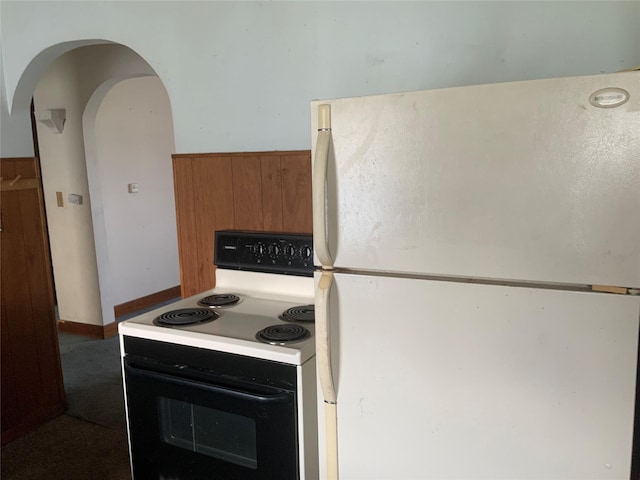 kitchen featuring wood walls and white appliances