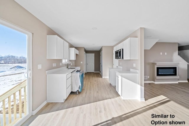 kitchen featuring sink, white cabinets, light hardwood / wood-style flooring, and appliances with stainless steel finishes