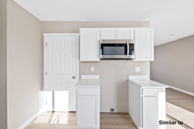 kitchen featuring white cabinetry and light hardwood / wood-style floors