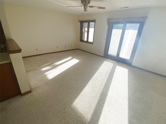 empty room with ceiling fan and light colored carpet