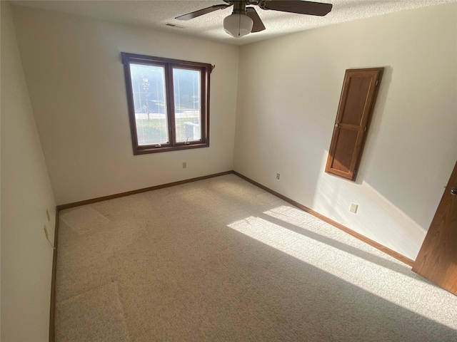 carpeted empty room featuring ceiling fan and a textured ceiling