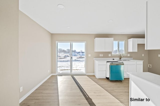 kitchen with sink, light hardwood / wood-style floors, white cabinetry, and dishwasher