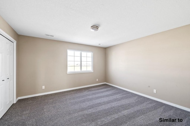 interior space featuring dark carpet and a closet