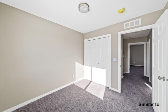 unfurnished bedroom with a closet and dark carpet