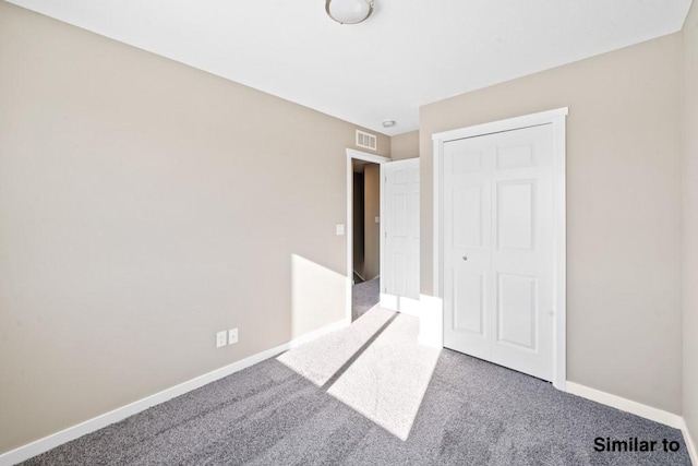 unfurnished bedroom with carpet floors and a closet