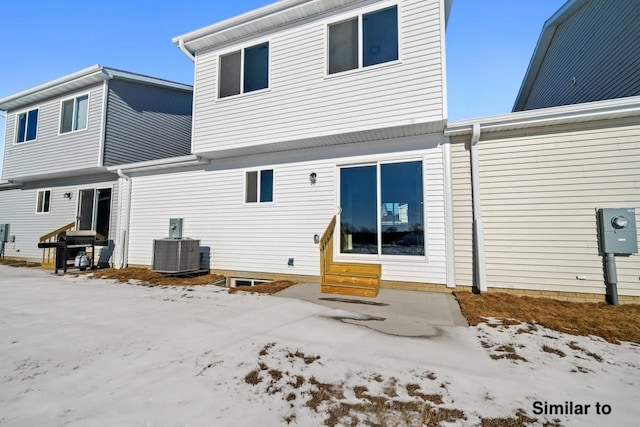 snow covered property featuring central AC unit