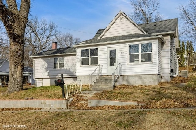 view of front of house featuring a front yard and central AC