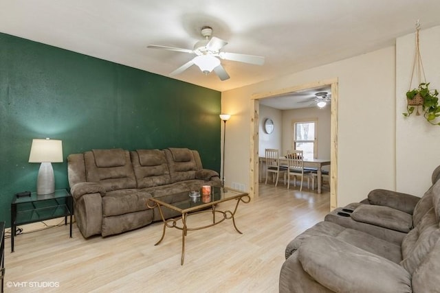 living room featuring ceiling fan and light hardwood / wood-style floors