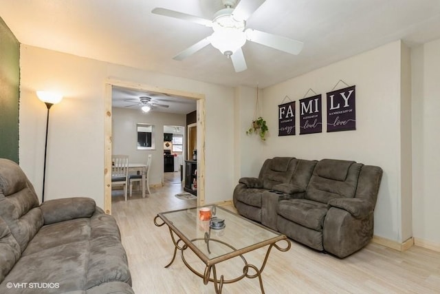 living room with ceiling fan and light wood-type flooring