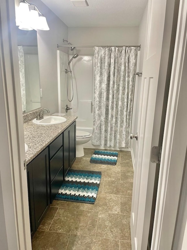 full bathroom with shower / bathtub combination with curtain, vanity, a textured ceiling, and toilet