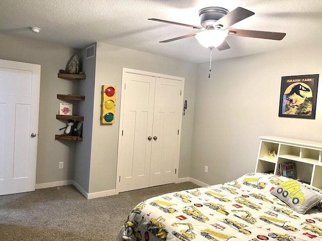 bedroom featuring ceiling fan, dark carpet, a textured ceiling, and a closet