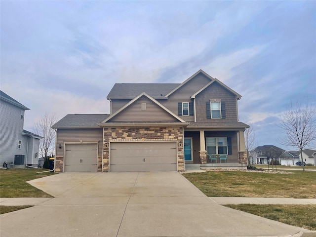 craftsman-style house featuring a front yard, central AC unit, a porch, and a garage