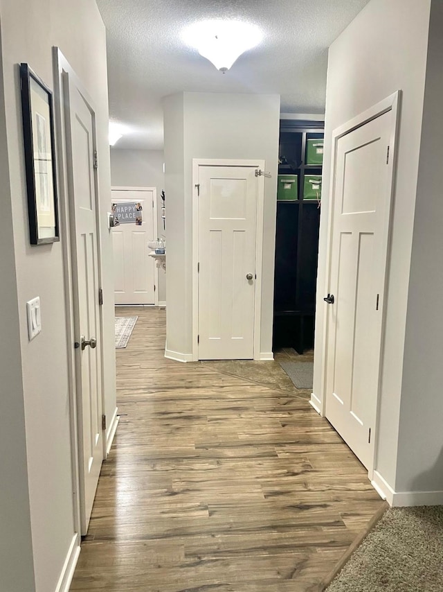 corridor featuring hardwood / wood-style floors and a textured ceiling