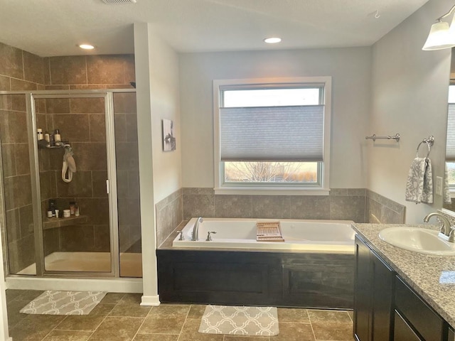 bathroom with tile patterned floors, vanity, and shower with separate bathtub