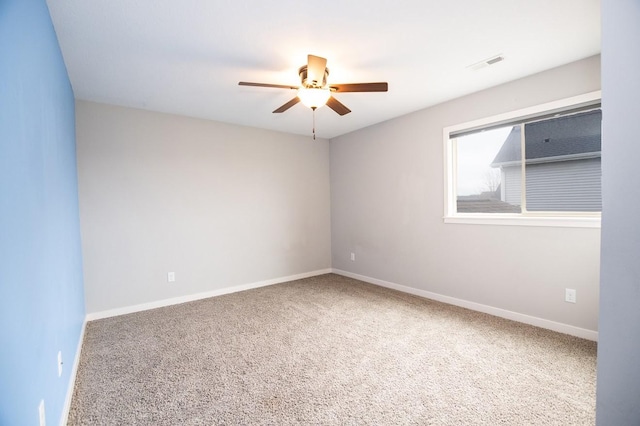 carpeted empty room featuring baseboards, ceiling fan, and visible vents