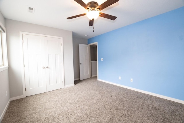 unfurnished bedroom with a closet, baseboards, ceiling fan, and carpet flooring