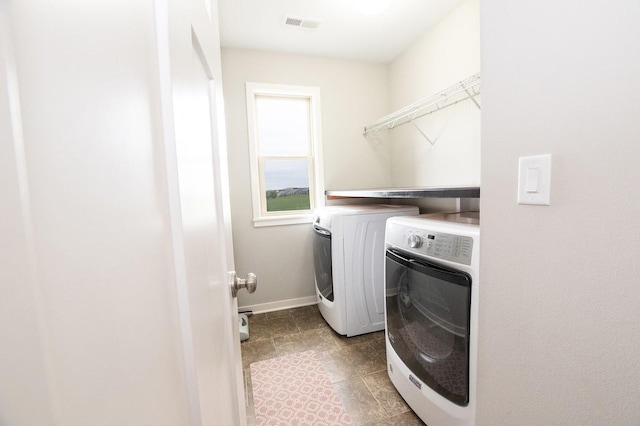 washroom featuring laundry area, independent washer and dryer, visible vents, light tile patterned floors, and baseboards