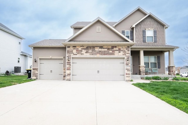 craftsman-style home featuring an attached garage, a front lawn, stone siding, a porch, and concrete driveway