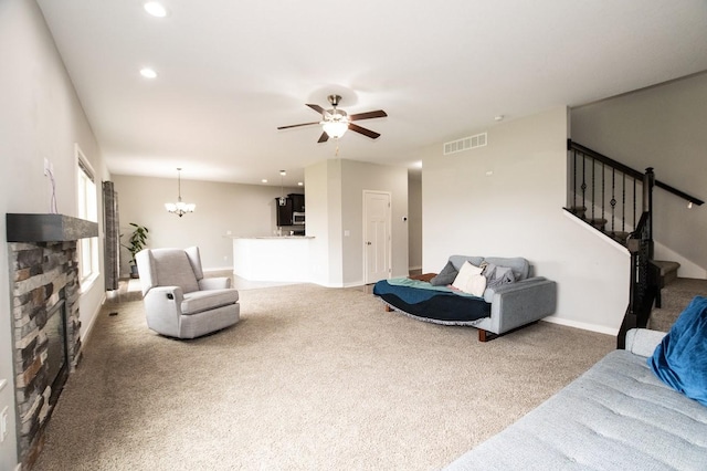 carpeted living area with visible vents, stairs, baseboards, recessed lighting, and ceiling fan with notable chandelier