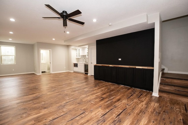 unfurnished living room with baseboards, recessed lighting, wood finished floors, and beverage cooler