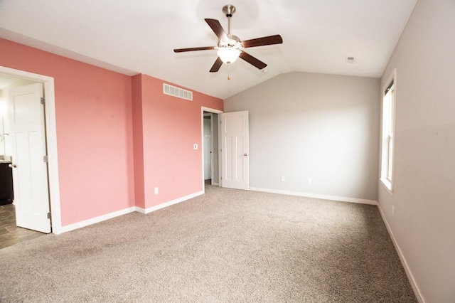 empty room with carpet floors, ceiling fan, visible vents, and lofted ceiling