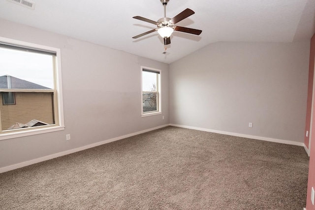 unfurnished room featuring carpet floors, a ceiling fan, baseboards, lofted ceiling, and visible vents