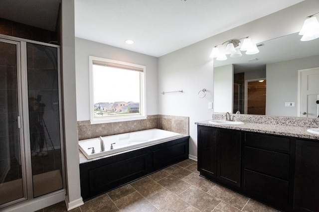bathroom with a sink, double vanity, a shower stall, and a garden tub