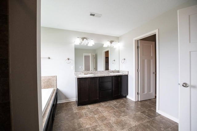 bathroom with a sink, baseboards, double vanity, and visible vents
