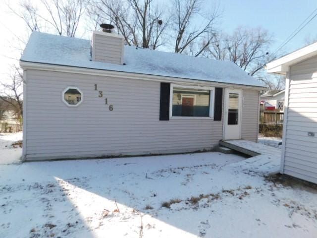 view of snow covered back of property