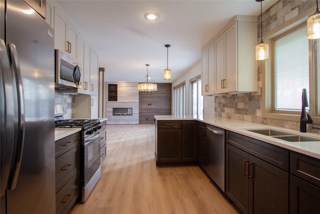 kitchen featuring white cabinets, appliances with stainless steel finishes, a wealth of natural light, and sink