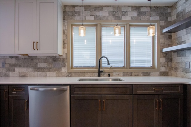 kitchen featuring dishwasher, dark brown cabinetry, sink, and decorative light fixtures