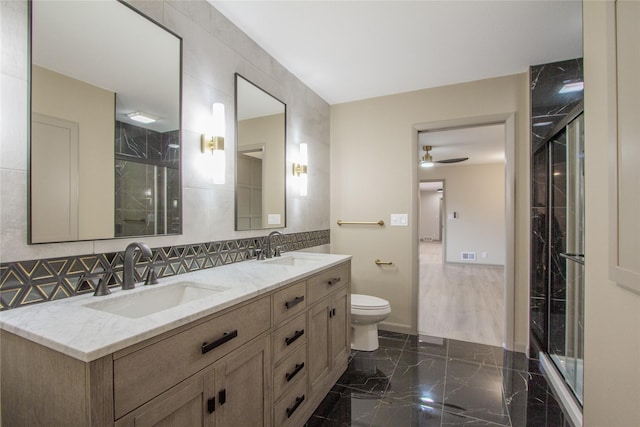 full bathroom with combined bath / shower with glass door, vanity, ceiling fan, tile walls, and toilet