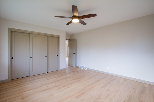 unfurnished bedroom with light wood-type flooring, a closet, and ceiling fan