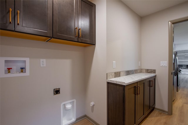 washroom with hookup for an electric dryer, hookup for a washing machine, cabinets, and light wood-type flooring