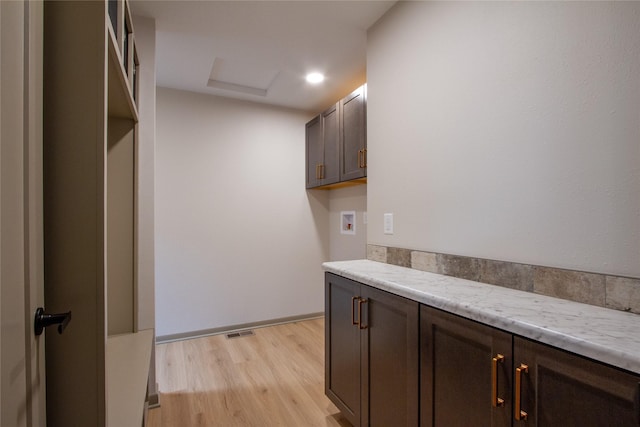 laundry area featuring light hardwood / wood-style floors, cabinets, and hookup for a washing machine