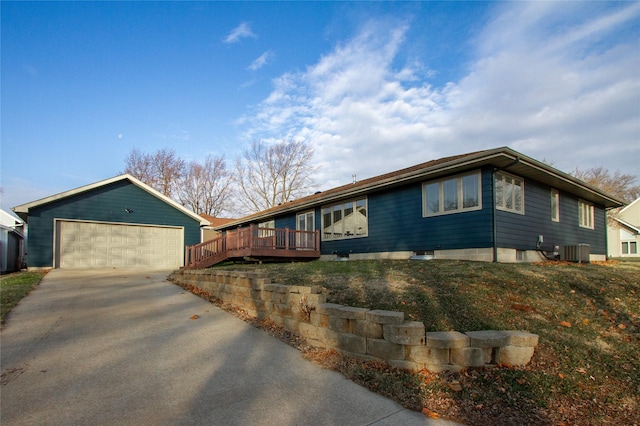 ranch-style house featuring cooling unit, a garage, and a deck