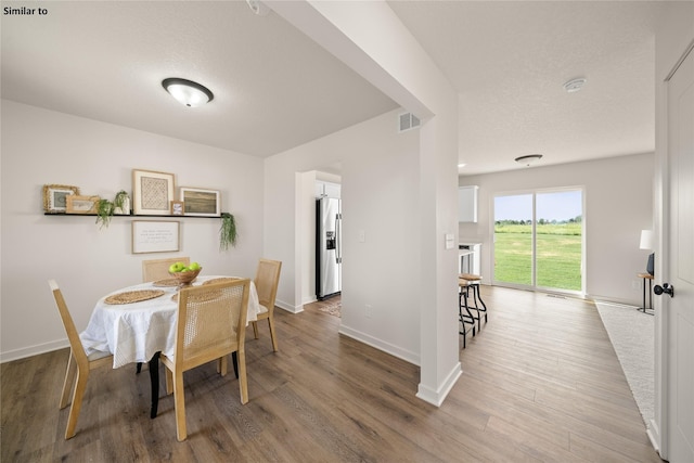 dining room with a textured ceiling and hardwood / wood-style flooring