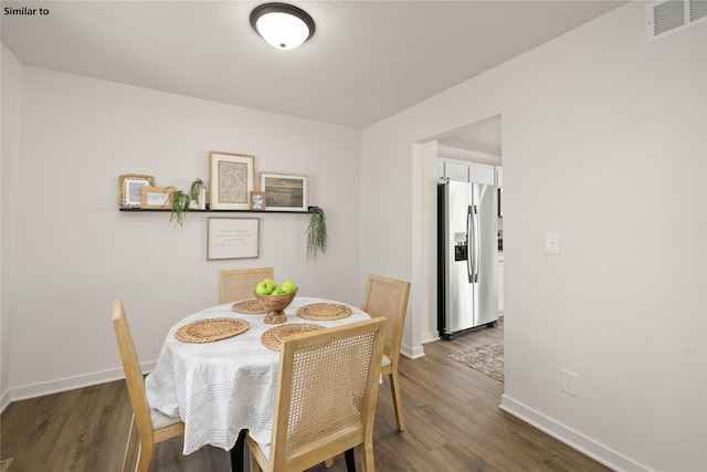 dining area featuring dark wood-type flooring