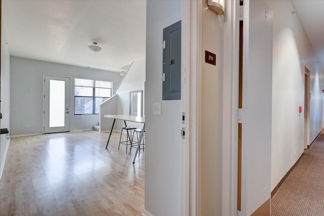 corridor featuring electric panel and light hardwood / wood-style flooring