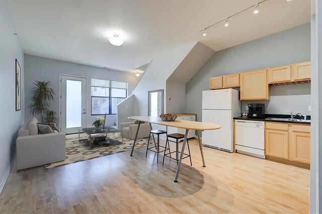 kitchen with light brown cabinetry, light hardwood / wood-style floors, white appliances, and sink