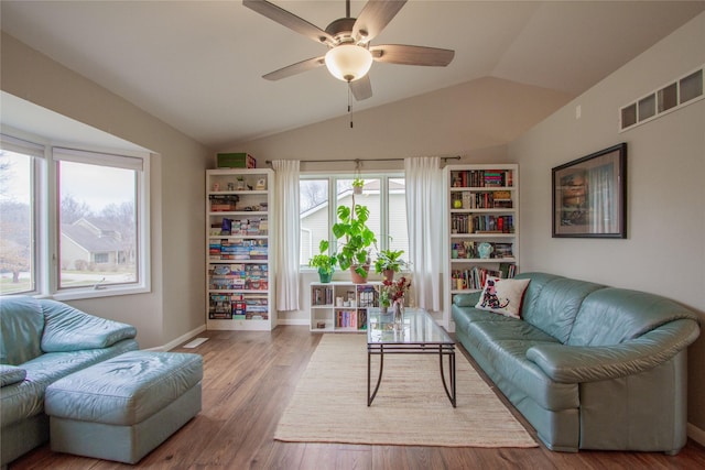 living room with light hardwood / wood-style floors, vaulted ceiling, and ceiling fan