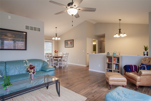 living room with wood-type flooring, ceiling fan with notable chandelier, and lofted ceiling